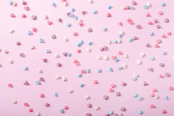 background candy sweets or pastel colored chocolate chips on a pink background that form a nice texture