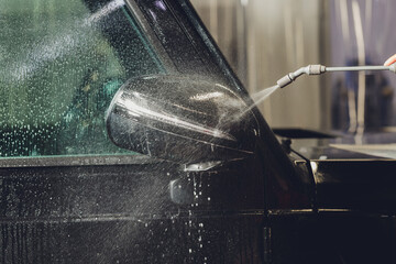 Close up of paint protection film installation on side mirror of modern luxury car. PPF is...