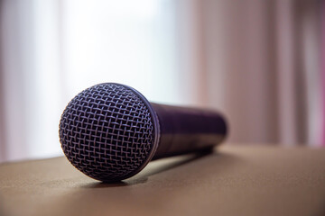 Microphone on the back table, light shines through the curtain.