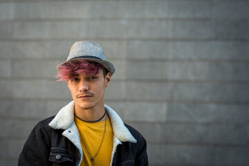 Alternative young teenager portrait looking on camera - violet diversity hair and grey urban...