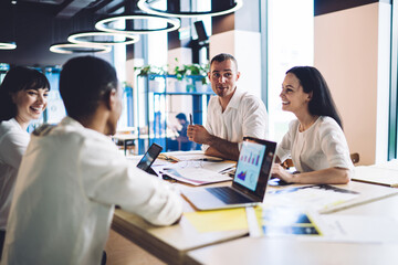 Smiling colleagues with papers and devices during conference