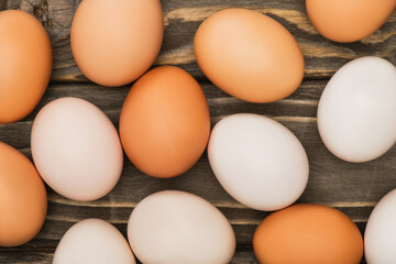 top view of fresh chicken eggs on wooden surface