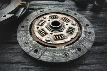 Old car clutch disk on the black workbench background.