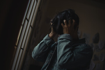 chico desesperado frente a una ventana con barrotes/
desperate boy in front of a window with bars