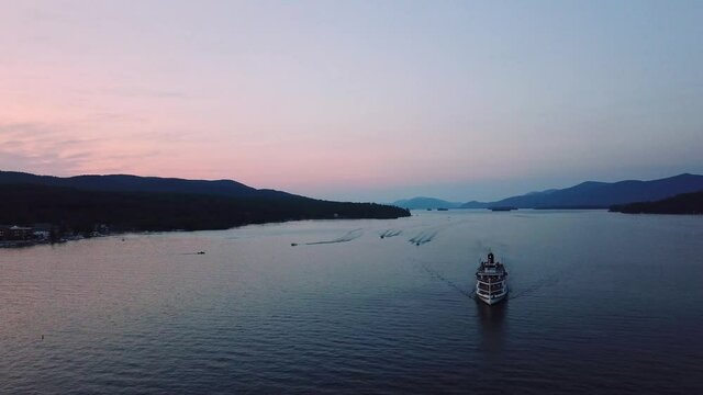 Aerial view of a steamboat moving on a lake in the Adirondacks during sunset
