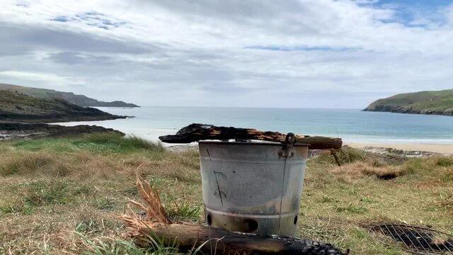 Time Lapse of wood burning in a Camp Bucket Barbecue Grill with the Ocean as Background. BBQ, Camping