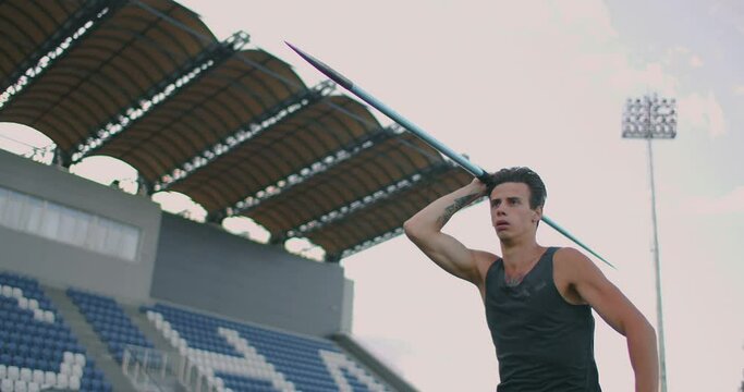 Run-up and javelin throw at the stadium. Slo-Mo Shot of Young Man Throwing Javelin. One caucasian man javelin thrower on stadium