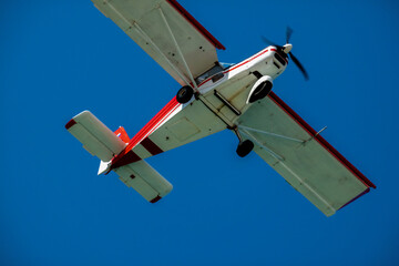 Obraz premium Light-engine two-seat aircraft in the air close-up. Bottom view.