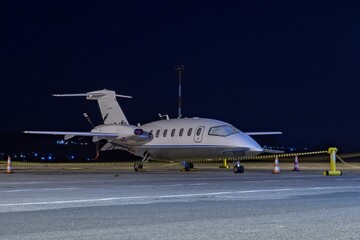 Front side view of white business airplane with twin turboprop engines mounted in pusher...