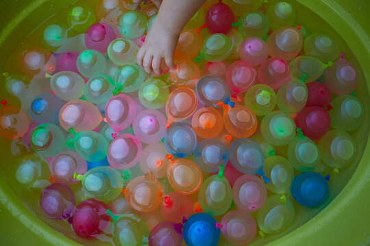 Many Colorful Water Balloons In A Plastic Basin