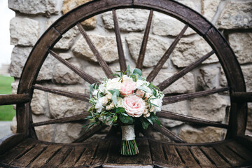 Front view of beautiful wedding bouquet made of eustomas, rose on wooden bench. Traditional wedding accessory for bride. Pretty bunch of flowers for valentines day. Concept of unexpected surprise.