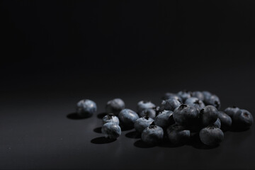 Water drops on ripe sweet blueberry. Fresh blueberries background with copy space for your text. Vegan and vegetarian concept. Macro texture of blueberry berries.