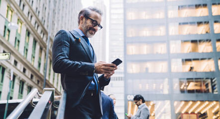 Smiling mature businessman using smartphone in New York