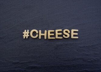 "#Cheese" written out of cheese. Text cut out of cheese.  Food art, edible decoration.