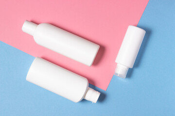 Cosmetic white bottles lie on a bright background. Means for face and body care at home and in a beauty salon.