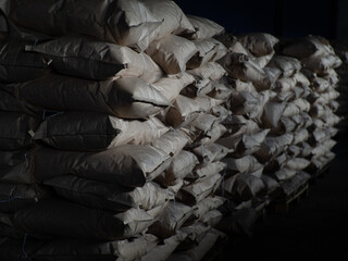 Full brown kraft paper bags with charcoal, at a coal plant, bags background stacks
