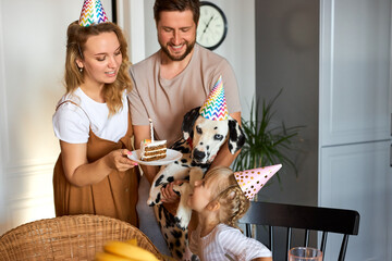 beautiful happy family celebrate birthday together, sit in the kitchen wearing party hats, man...