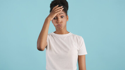 Portrait of upset casual african american girl tiredly posing on camera over colorful background