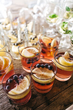 Top view of glasses full of tasty fresh juice with lemon slices and blueberry. Alcohol free delicious drinks on luxury gender party. Sober baby shower celebration. Concept of taste and food.