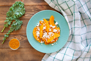Tasty pumpkin salad on rustic background, top view.