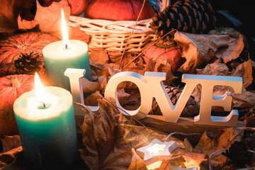 Autumn harvest of pumpkins. Pumpkin in a white basket. Yellow leaves. The inscription love.