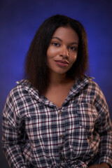 Groomed female student with positive attitude staynds in foggy purple background.