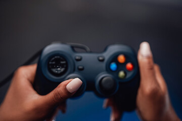 Modern gaming entertainment and sport field. Feminine blackskinned hands holds gaming device in smoke blue background.