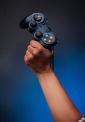 Pretty hands of afro woman grips the modern gaming joystick and lifting it up. Youth modern hobby and sport platform.