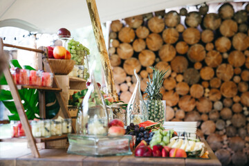 Close up of delicious fresh fruits on wedding celebration sweet buffet in village style. Table catering with watemelon, grapes, pineapple, exotic fruits. Waiting for guests. Concept of healthy party.