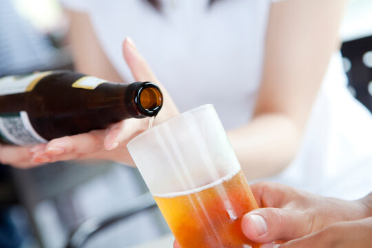 瓶ビールを注ぐ手元