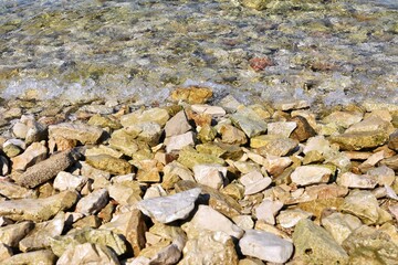 rocky stone beach in Croatia. Adriatic sea. Close-up of water with pebbles. Clean clear sea water and rocky coast
