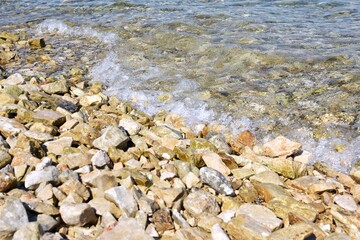 rocky stone beach in Croatia. Adriatic sea. Close-up of water with pebbles. Clean clear sea water and rocky coast
