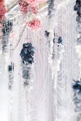 Close up of tender elements of wedding decoration in white, blue and dim pink colors. Interior design for pompous wedding celebration. Elegant floral decor for girly birthday party. Concept of beauty.