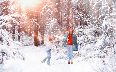 Young family for a walk. Mom and daughter are walking in a winter park.