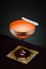 Refreshing and delicious coconut cocktail served with a biscuit in. a copper cup.