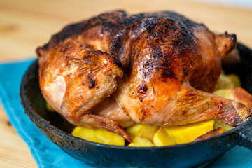 Baked crispy chicken with potatoes on an old frying pan
