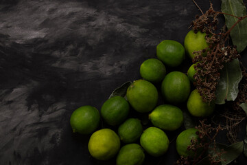 Background organic lemons and eucalyptus leaves on black background and rustic branches with berries
