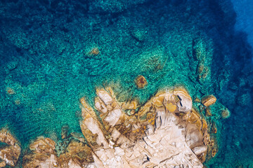 Aerial photo over granite rocky coastline Mediterranean crystal clear blue sea water. Aerial photo of ocean waves hitting rocky coastline of beautiful paradise dream tropical beach. Sardinia, Italy.