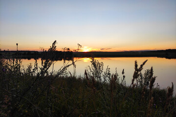 Obraz premium summer sunset over the pond in clear weather