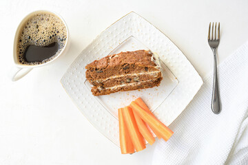 Slice of carrot cake and coffee on white background