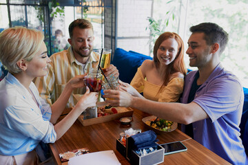 two married couples got together in a restaurant, spend free time in weekends. have meal and talk. friendship, people, communication concept