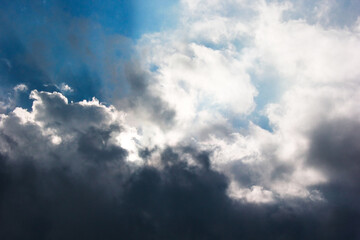 Naklejka na ściany i meble Backdrop of the sky, rain clouds and rays of the sun.