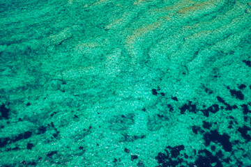 Sea surface aerial view. Background image of the turquoise sea. Deep sea and corals. Aerial drone shot of turquoise water, space for text. Aquamarine background. Sea Aerial view.
