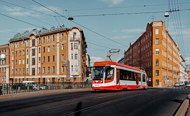 Obraz premium Modern city tram crossing bridge in St. Petersburg. Public transportation concept. City background, banner.