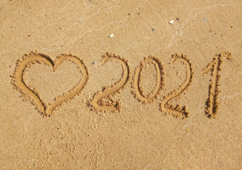 2021 inscription on the sand of the beach. Summer beach holidays in 2021. The message is handwritten. The concept of the new year