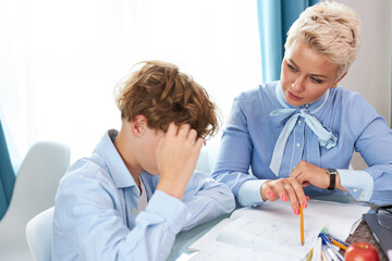 Obraz premium young intelligent teacher explain math or geometry to student, female tutor came at home, enjoy sharing knowledge with boy