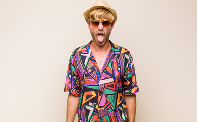 blonde adult traveller manfeeling disgusted and irritated, sticking tongue out, disliking something...