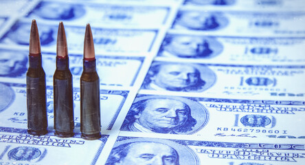 Bullets against US Dollar bills background as an abstract symbol of business, military conflicts and murders.