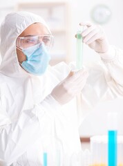 Young chemist student working in lab on chemicals