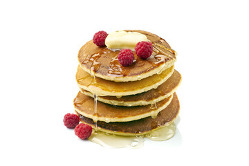 Stack of pancakes with butter, honey and raspberries on white